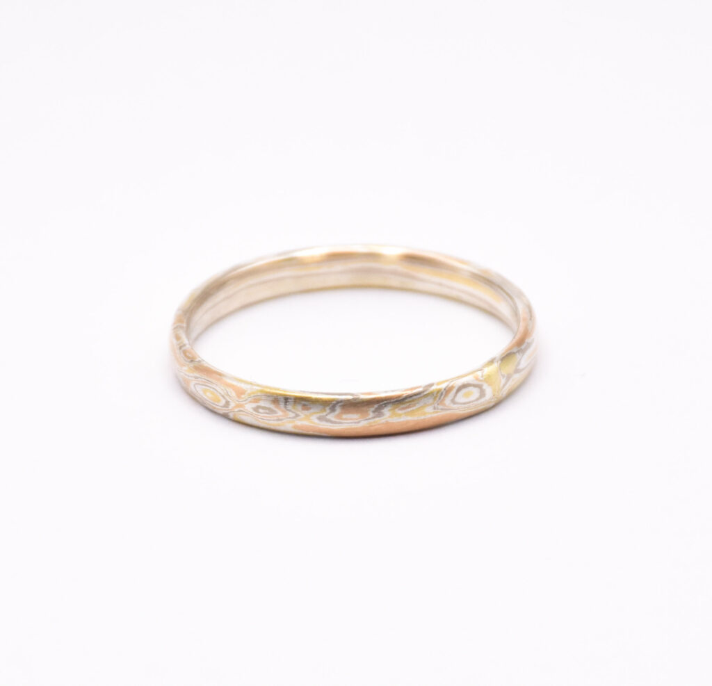Antoine Puygrenier, artisan bijoutier joaillier. Alliance en mokume-gane, mokoumé gané or jaune rouge et gris. Bague avec couronne de feuille gravée à l'échoppe. Bijoux sur-mesure, unique et personnalisée. 